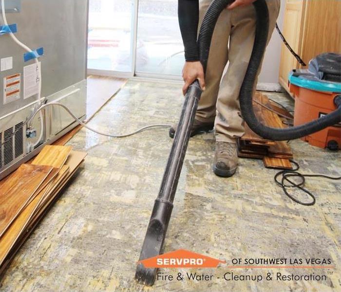 A SERVPRO Restoration Tech extracting flood water from a floor in a Las Vegas home to prevent water damage.