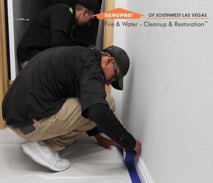 SERVPRO Restoration Technician taping up the floor with a protecting cover before starting the restoration process.