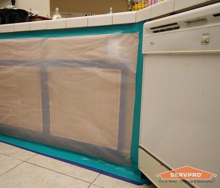 We professionally covered these kitchen cabinets to make sure they don't get damaged in the restoration process.